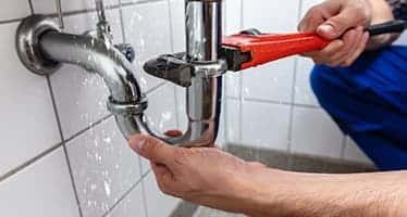 Plumber Fixing Leaking Sink — Plumbers & Electricians in the Southern Highlands, NSW