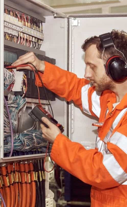 Electrician checking continuity in circuit box — Plumbers & Electricians in the Wollongong Region, NSW